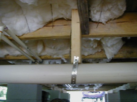 The parish requires R-13 underneath the floor. Notice the steel wire "Tiger Teeth" that easily hold the insulation in place. You should not have a vapor barrier here because moisture might accumulate above it. So just tear off the vapor barrier so it can breathe.