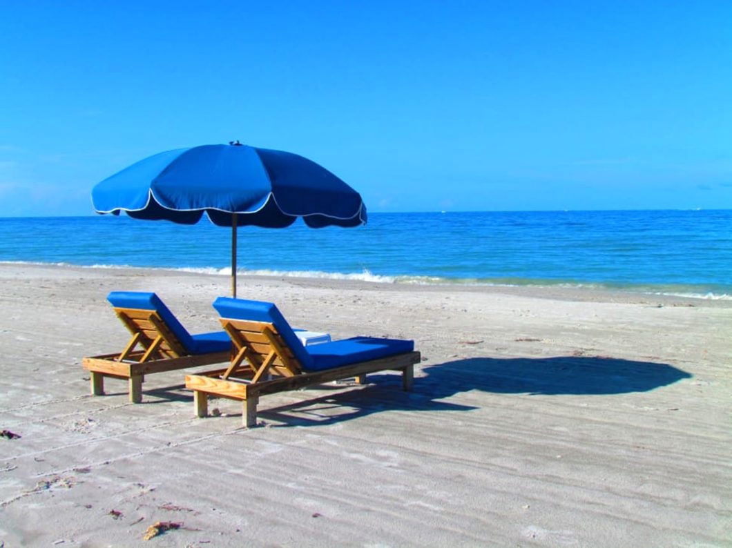 Chaise lounges and umbrella by the beach